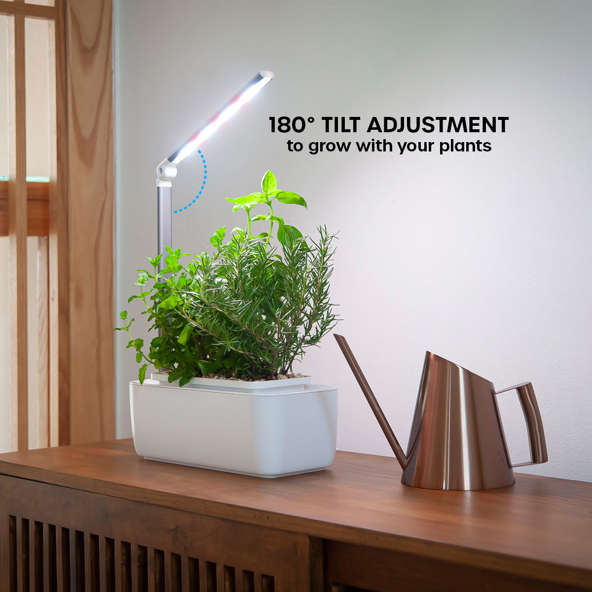 HydroGarden Classic with herbs and tilted light with a watering can in a home environment.